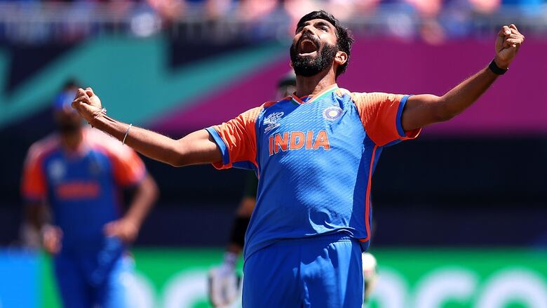 A man celebrates on a cricket pitch.