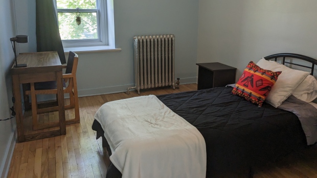 New transitional housing project for Indigenous people opening in Montreal's Milton Park; A bedroom with a single bed, a window, a dresser and a desk\. 