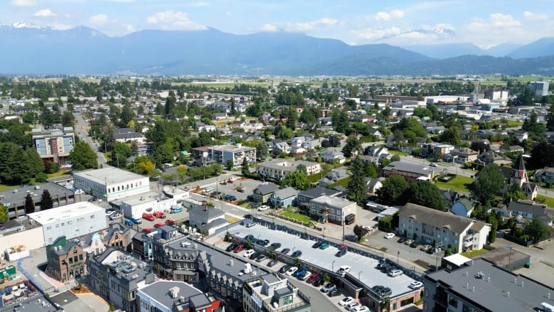 A drone shot of Chilliwack apartment's, homes, and mountains in the distance. 