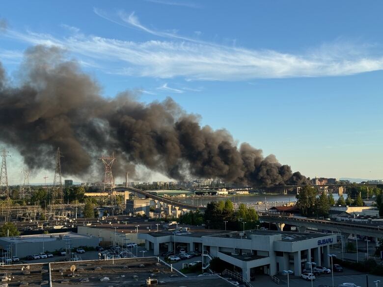 Black smoke rises above a city. 