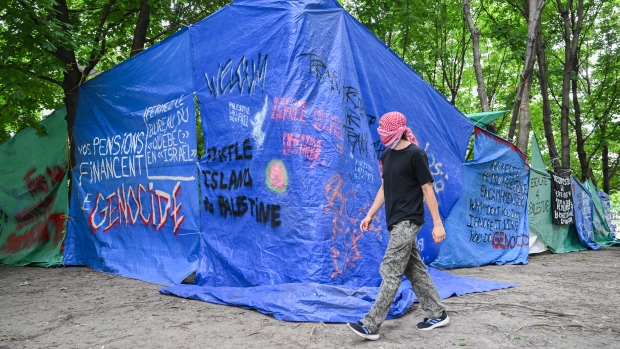 New pro-Palestinian encampment set up at Victoria Square in downtown Montreal; A Pro-Palestine supporter puts up fencing at an encampment set up in Square Victoria in Montreal, Saturday, June 22, 2024\. Police say protesters began barricading themselves in Victoria Square using construction materials at around 1:20 p\.m\. on Saturday\. THE CANADIAN PRESS/Graham Hughes
