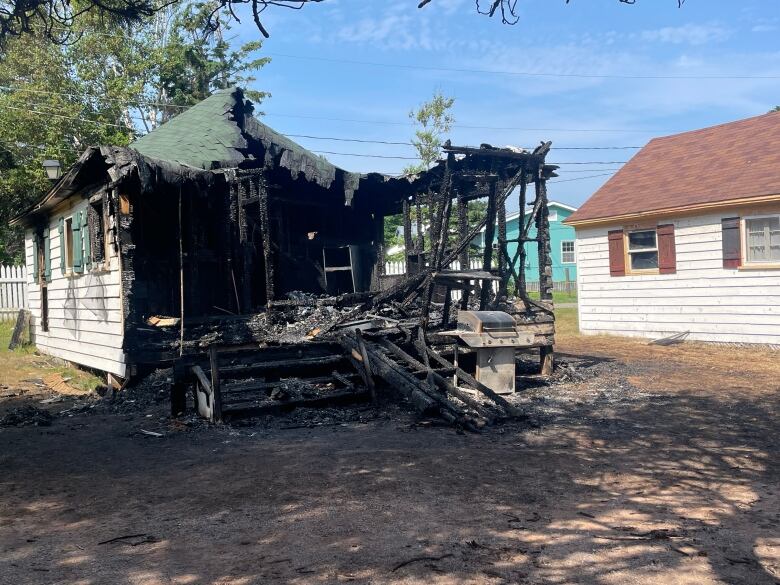 The charred remains of a burned-down cottage.