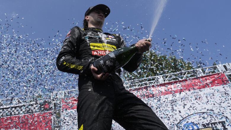 A race car driver celebrates.