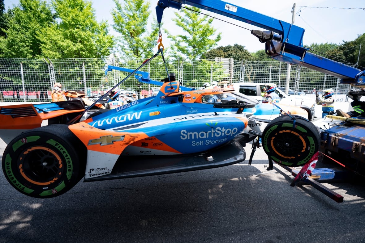A race car is hoisted on a two truck.