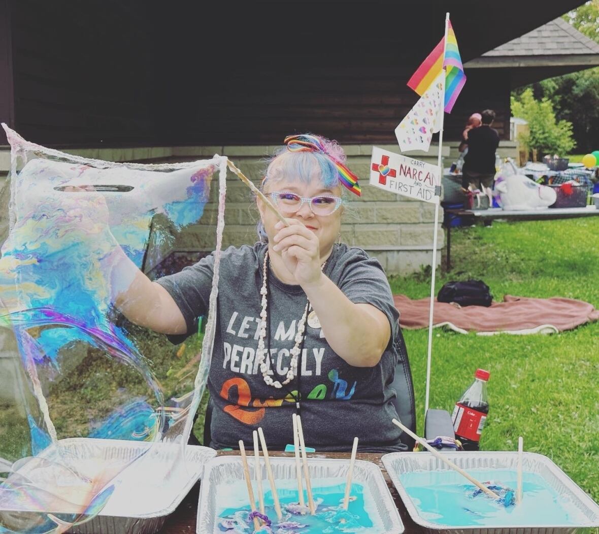 A woman blows a large bubble at a table.