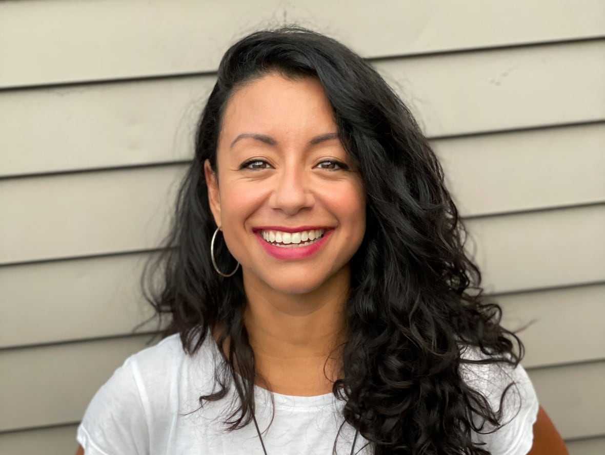 A woman smiles at the camera. 