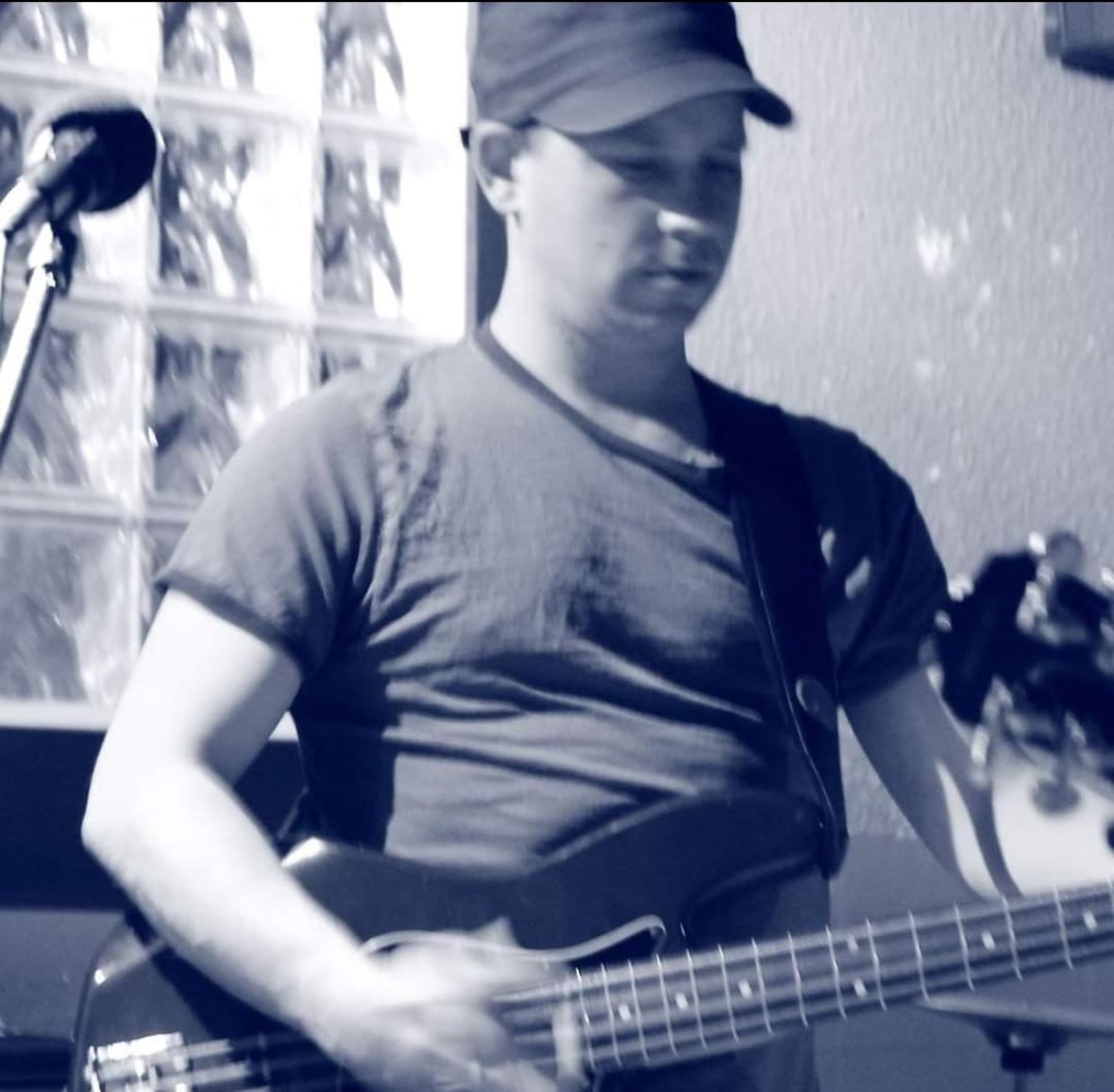 A black and white photo of a man playing guitar. 