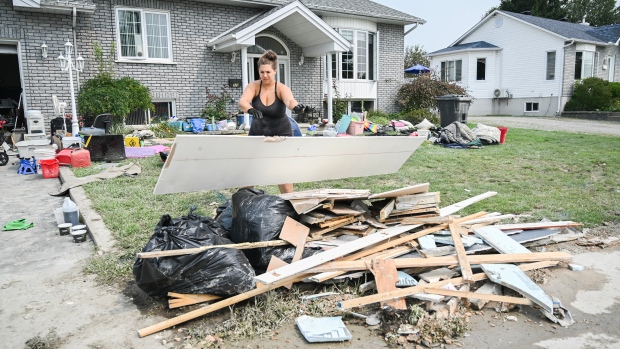 Homes damaged by floods could be renovated to withstand future flooding. So why aren't they?; A woman dumps drywall damaged by flood waters next to a house in Louiseville, Que\., Thursday, August 15, 2024, following a storm that dumped up to 175 millimetres of rain across the province\.