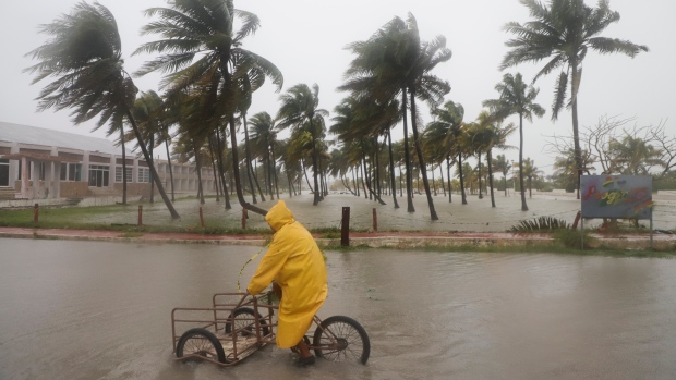 How dangerous is Hurricane Milton? Here's what we know; A person rides his bike through a flooded street amid rain as Hurricane Milton passes off the coast of Progreso, Yucatan state, Mexico, Tuesday\. 