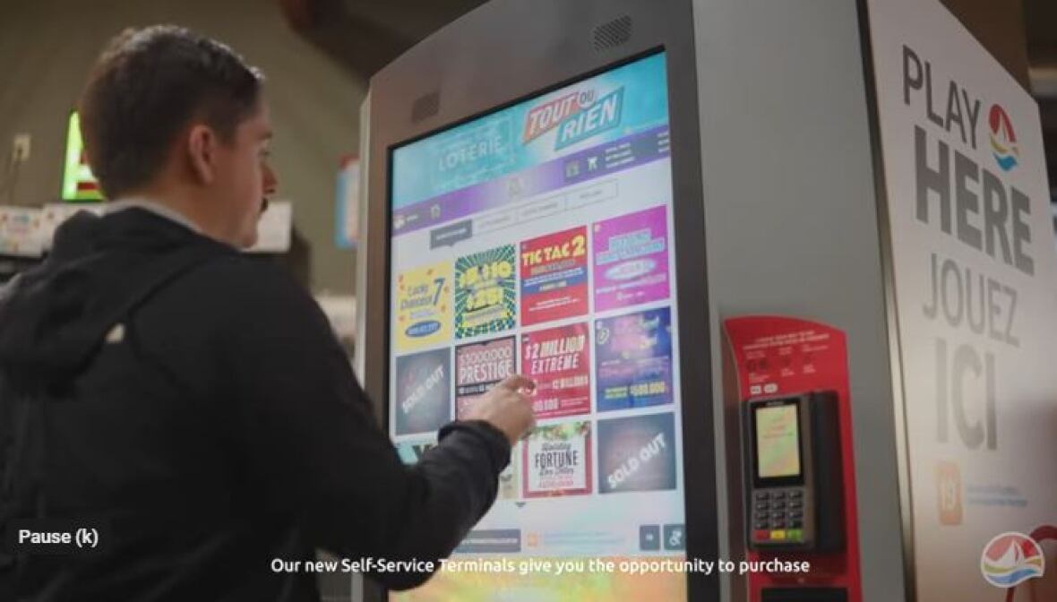 A man chooses lottery ticket options from the colourful screen of a machine that has a slot for a credit card. 