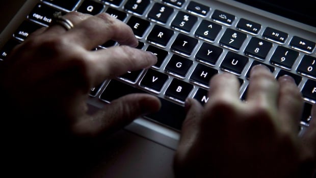 A woman uses her computer keyboard to type while surfing the internet in North Vancouver, B.C., on December 19, 2012.
