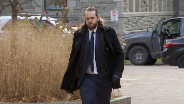 A man walks outside in a jacket.