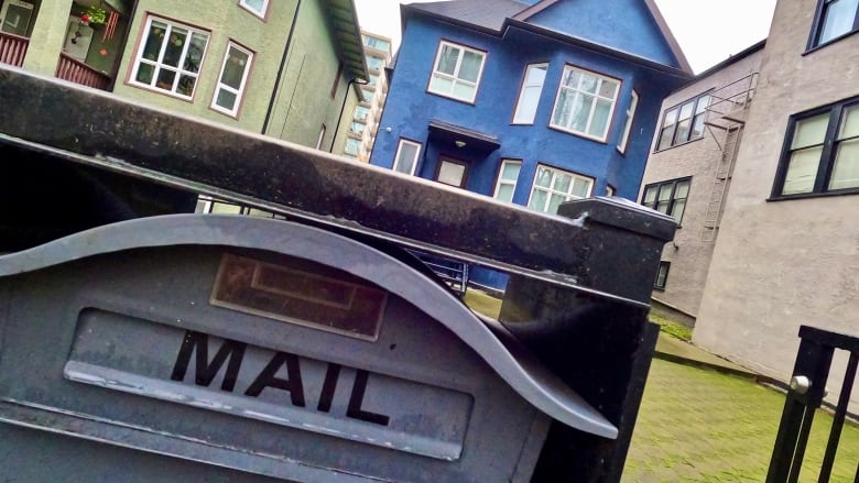 A mail box in front of colourful homes