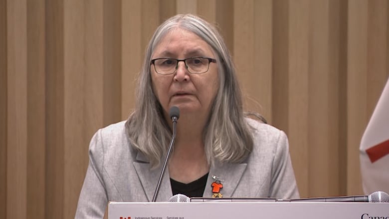 A woman stands at a podium.