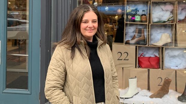 Shelley DeMerchant of the Urban Shoe Myth says she is excited for the future of the projects around her but would like to see more communication of potential impacts. Woman standing in front of store and smiling at camera.
