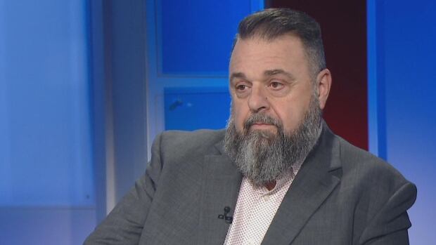Hal Perry wears a grey suit jacket on the set of CBC News: Compass