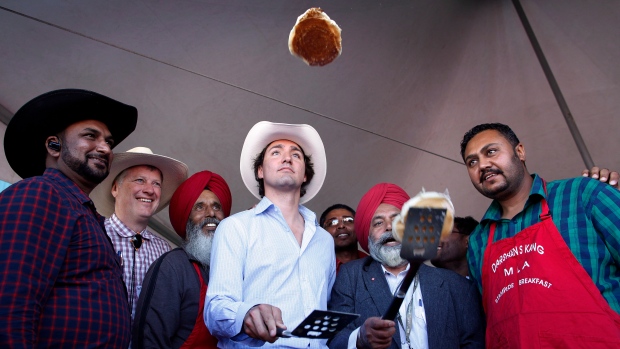 Trudeau tried to exorcise family ghosts out west. His own spectre may linger; Liberal Leader Justin Trudeau, centre, flips pancakes at a Stampede breakfast in Calgary, Alta\., on Sunday, July 7, 2013\.