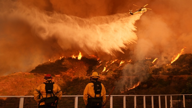 Death toll rises to 16 as firefighters work to prevent spread of California wildfires; Firefighters watch as water is dropped on the Palisades Fire in Mandeville Canyon Saturday, Jan\. 11, 2025, in Los Angeles\. \(AP Photo/Jae C\. Hong\)