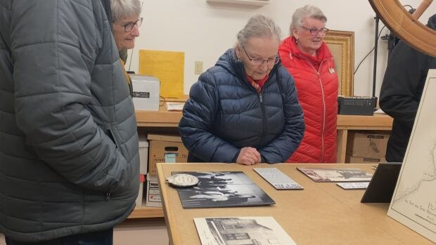 People from Three Rivers look at exhibits in the Garden of the Gulf Museum's artifactory in Montague during an open house on Saturday, Jan. 18, 2024. A group of people look at artifacts on a table in a museum.