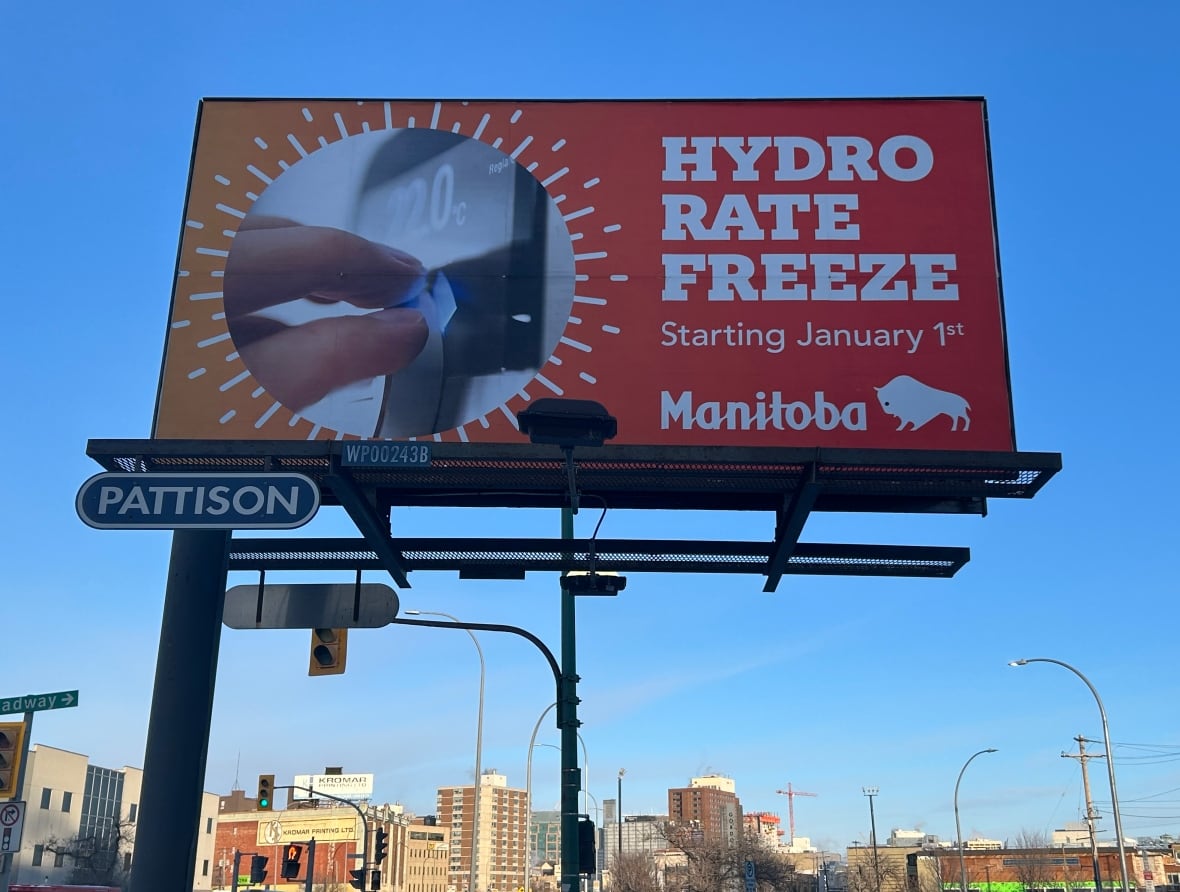 A billboard shows a person turning a temperature dial with the words 'Hydro rate freeze' and 'Starting January 1st' on it.