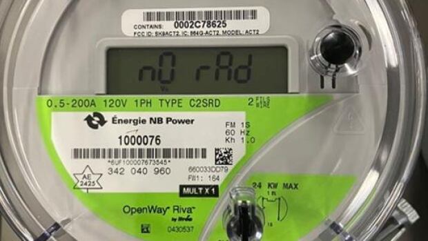 NB Power says it is confident its smart meters are functioning properly. A round gauge with a green sticker on the bottom half of the face that says NB Power on it an has some identification numbers. There's a small digital screen in the middle of the device. A barcode sticker and the name brand Centron can be seen near the top of the circle.