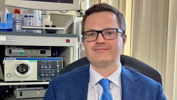 Daniel McIsaac, a scientist and anesthesiologist at The Ottawa Hospital, and Chair in Innovative Perioperative Care at the University of Ottawa, studies prehab for surgery patients. A man smiling wearing glasses and a blue suit, white shirt and lighter blue tie.