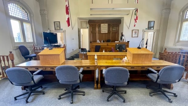 Owen Daniel MacDonald appeared in court by video link, while the Crown and defence appeared in person in Georgetown on Thursday. Four chairs are visible against the desk shared by the Crown and defence lawyers inside the Georgetown courthouse.