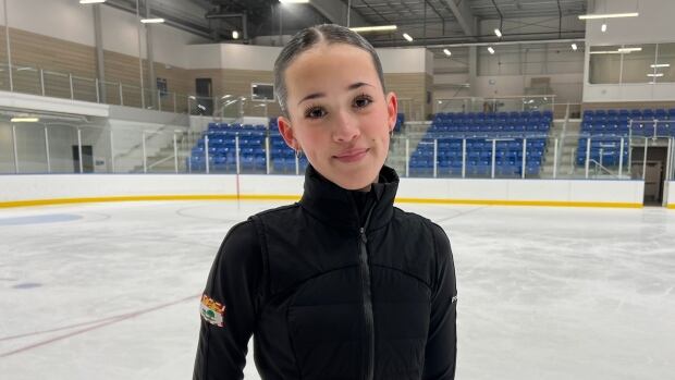 Brooklyn Spates will represent Prince Edward Island for the very first time at Skate Canada Trophy in Edmonton, a national-level competition. A girl wearing a black sweater stands on an indoor ice rink.