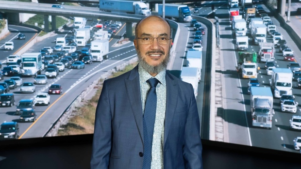 Why experts say work on these 5 fronts is needed to tackle Toronto's congestion crisis; Man in a suit standing in front of screens showing traffic\.