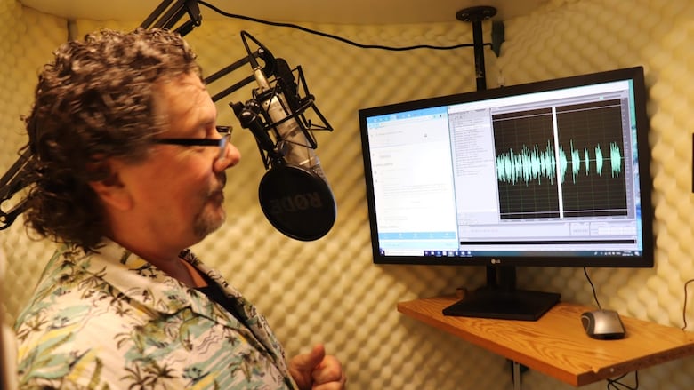 A man records his voice into a microphone. 