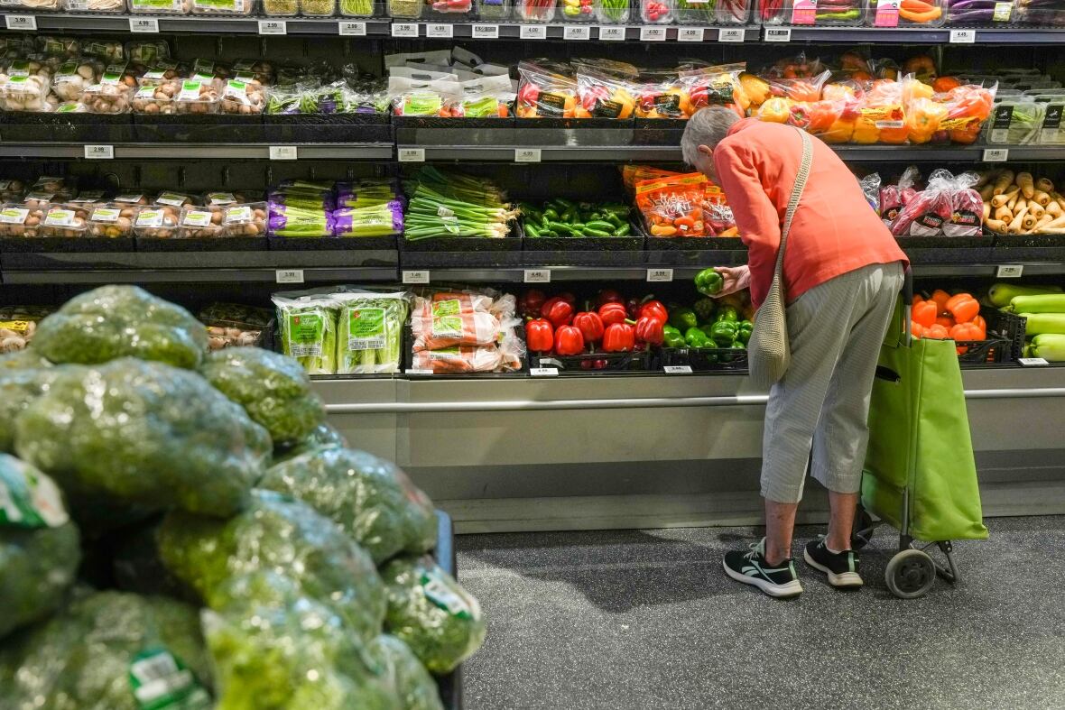 A person is seen shopping for produce.