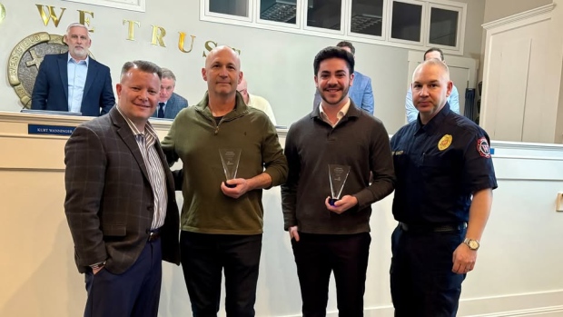 Indiana's 'Rope Warrior' awarded for saving drowning teen with his jump rope; Indiana jump-roper David Fisher, second from the left, and his son Felix, second from the right, are honoured with Lifesaving Citizen Awards from Westfield, Ind\., Mayor Scott Willis, left, and fire chief Rob Gaylor, right\. 