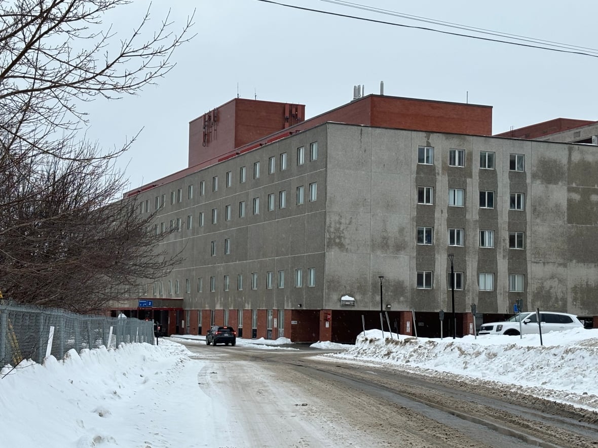 A building with several floors. A picture taken outside on a snowy day.