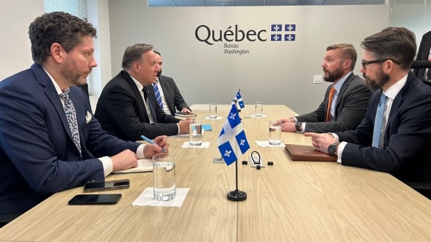Quebec Premier François Legault met with Kevin Wingert of the National Association of Home Builders in Washington, D.C., Tuesday. Men sit at a conference table with the Quebec logo on a wall in the background.