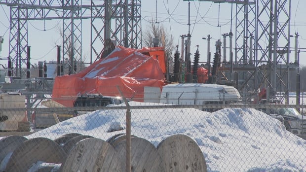 An orange tarp covers a damaged substation.