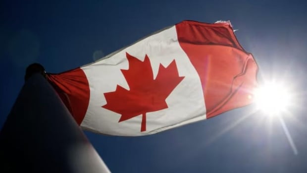 Canada’s flag, with a red maple leaf, blows in the wind.
