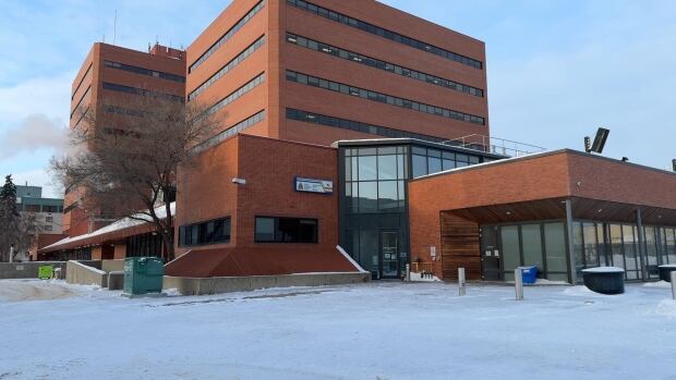 The municipality of Wood Buffalo developed a robust strategy to deal with encampments. Brown square high-rise building.