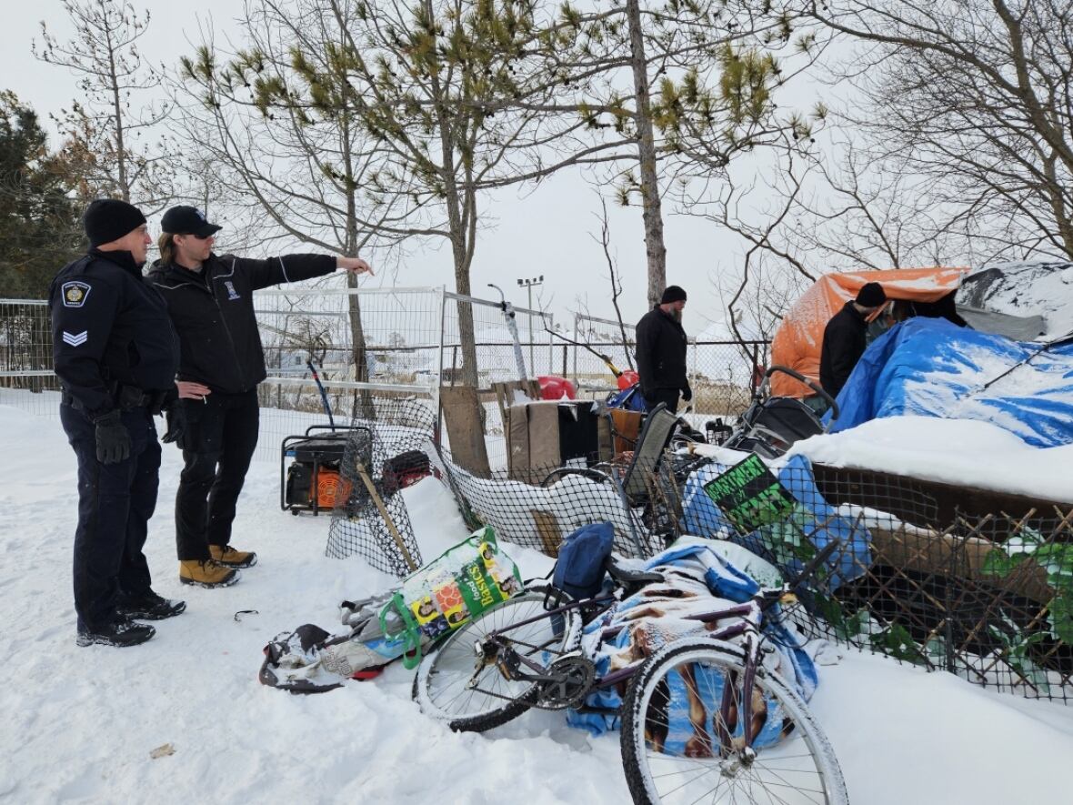A metropolis  bylaw enforcement serviceman  and constabulary  serviceman  survey   a information   of a stateless  encampment successful  Sarnia's Rainbow Park.