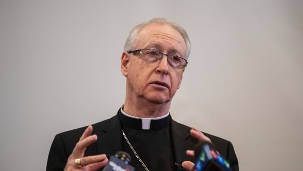 Archbishop Richard Smith shares his observations regarding his trip to Rome, in Edmonton on Monday, April 4, 2022. Pope Francis, who is hospitalized in critical condition with double pneumonia, has named Smith the new archbishop for Vancouver. A priest wearing a clerical collar speaks in front of microphones.