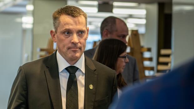 Alberta Finance Minister Nate Horner enters a news conference about Budget 2025, which includes the first deficit for province since the height of the pandemic. a man walks into a room