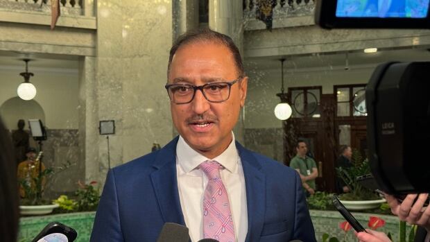 Edmonton Mayor Amarjeet Sohi speaks with reporters about Budget 2025 at the Alberta Legislature. A man in a suit stands in front of microphones.