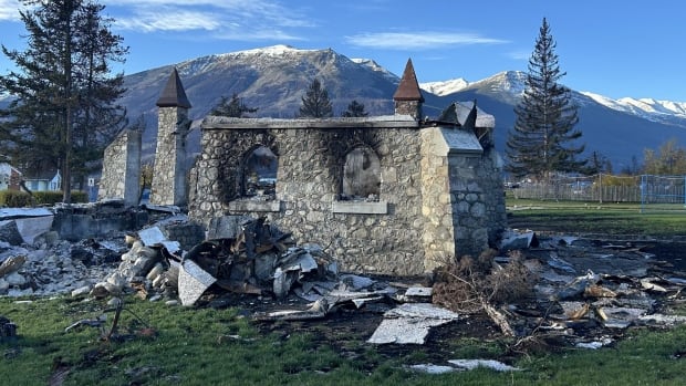 Only some stone portions of Jasper's Anglican Church remain after a July 2024 wildfire destroyed one-third of the Alberta rocky mountain town. Shows the burned remains of Jasper's Anglican Church.