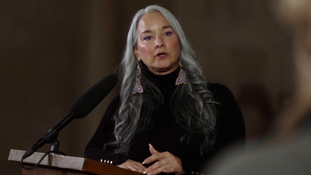A woman at a podium speaks.