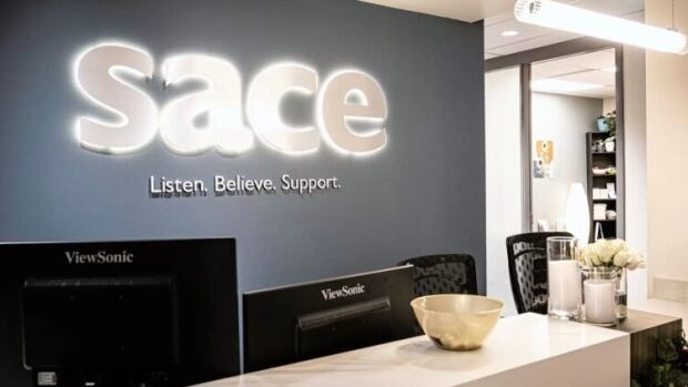 The Sexual Assault Centre of Edmonton says it has paused the intake of new clients and is blaming the province for cutting funds. A reception area with a sign that reads SACE.