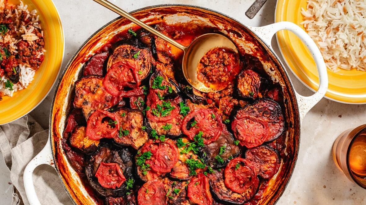 Top down shot of a ground beef, eggplant and potato casserole in a white cast iron pot. 
