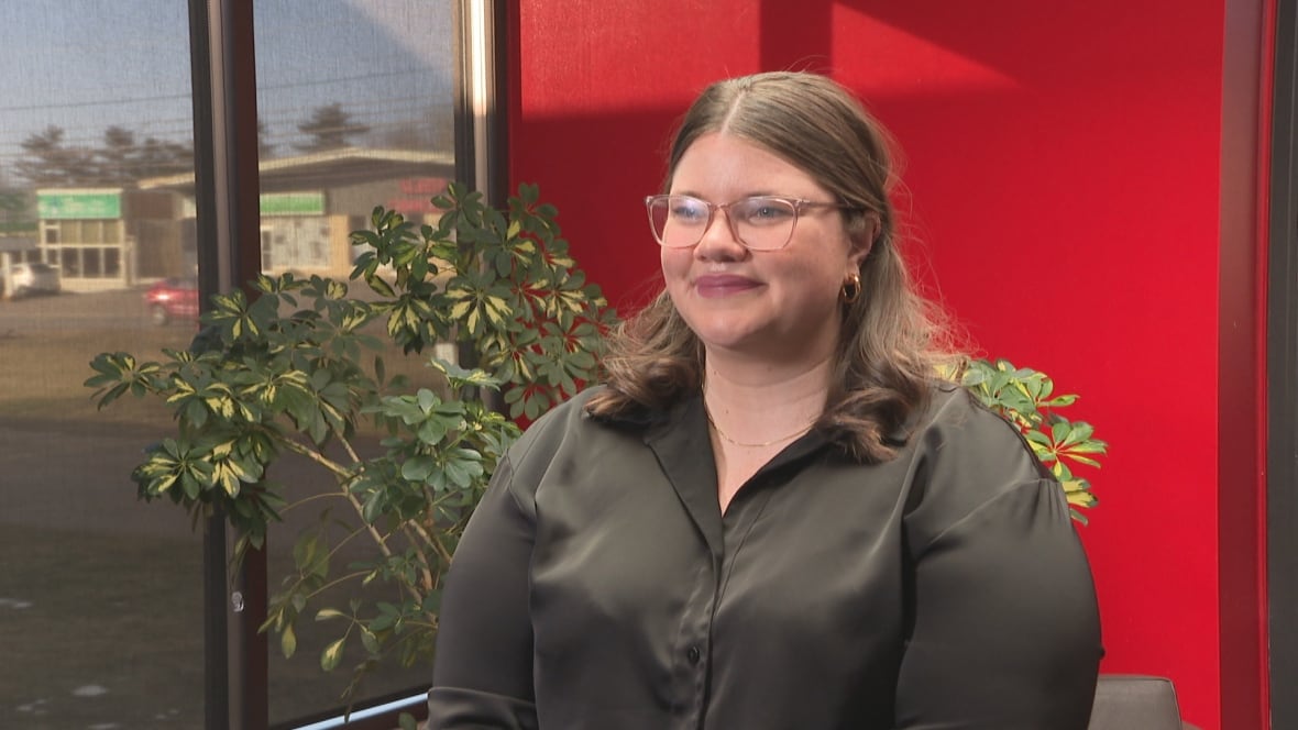 Woman wears glasses and button up shirt.