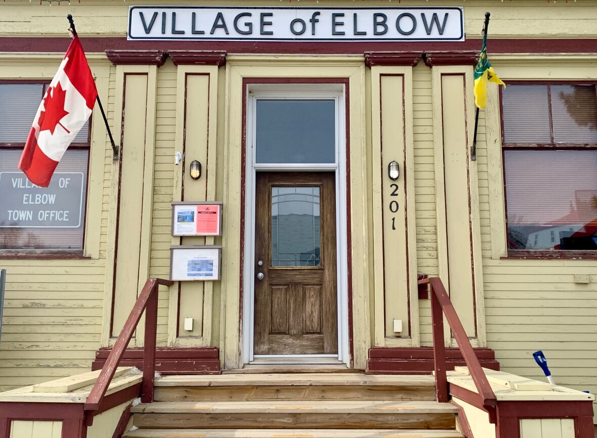 An aged  woody  gathering  with a motion   that says "Village of Elbow".