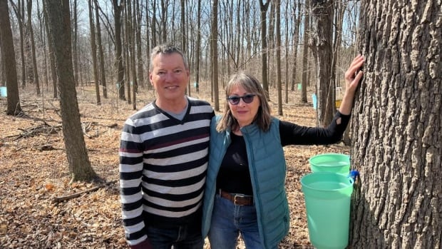 Bob and Leslie Meloche stand in the back of their Essex County, Ont. farmhouse property.