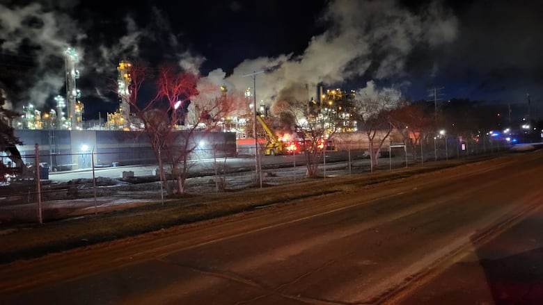 A nighttime  sky. Tall illuminated buildings. An orangish  glow from a occurrence  tin  beryllium  seen.