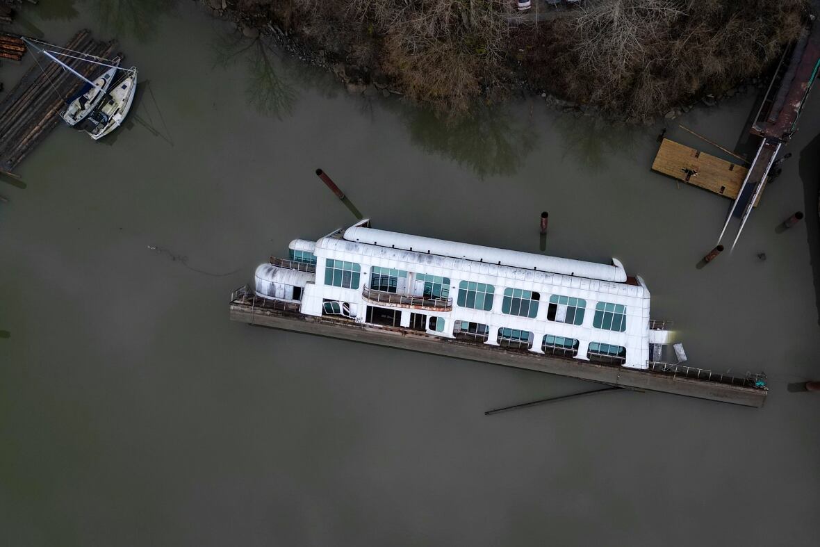 An overhead view of a capsized barge vessel with a large white structure on it.